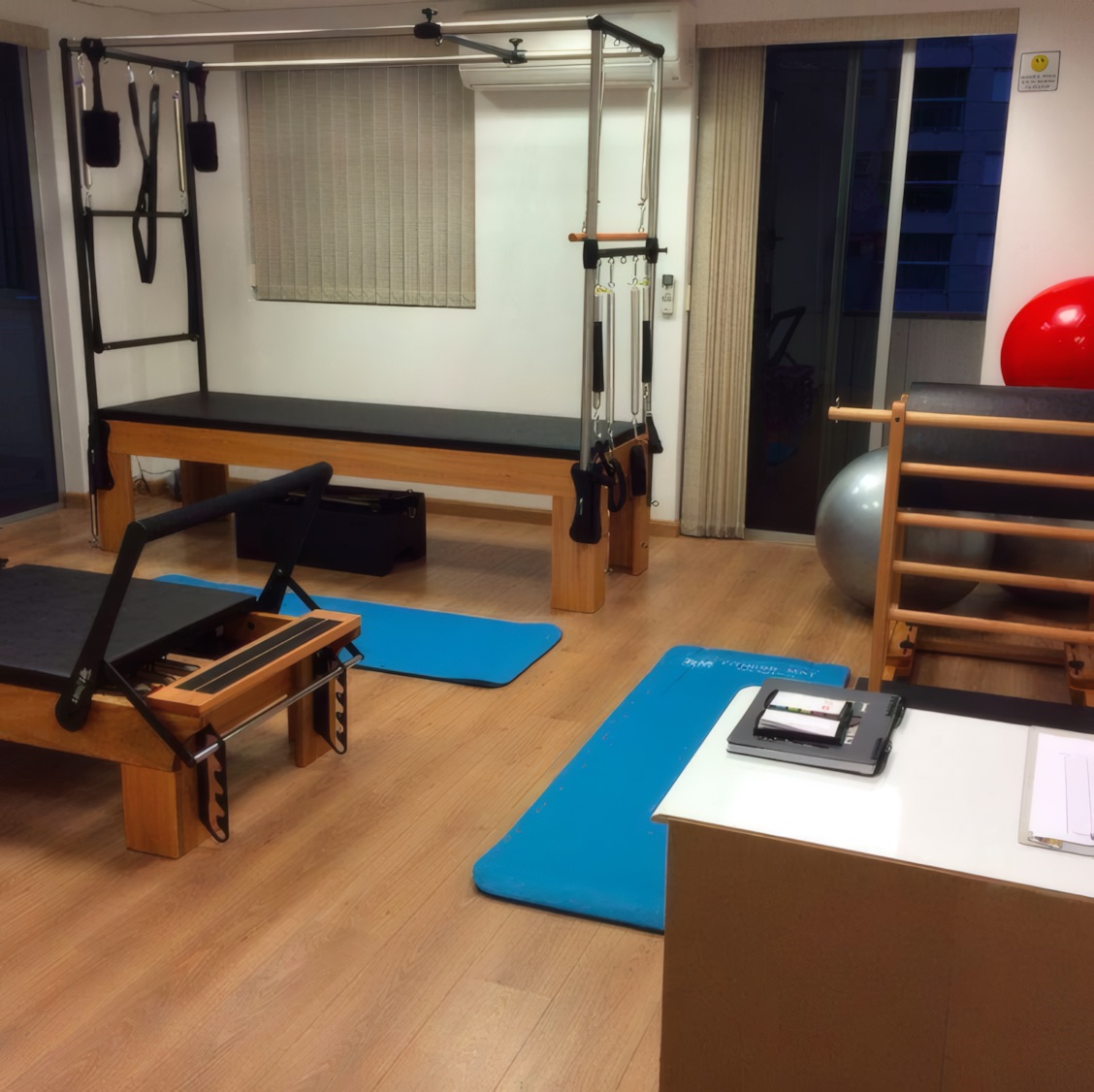 Aparelhos de pilates e tatames azuis no estúdio